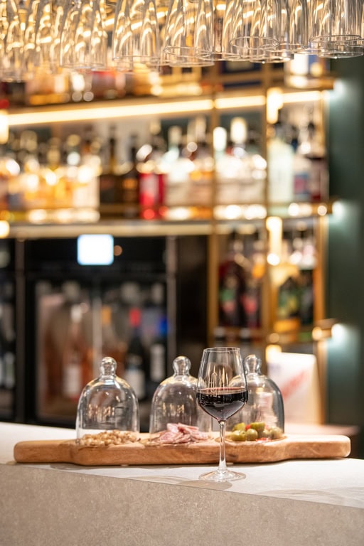 Un verre de vin rouge est posé sur le bar au Duke's Bar de l'hôtel de la cité.